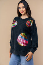 Load image into Gallery viewer, Woman wearing a black sweater with colorful sequin embellishments on a beige background