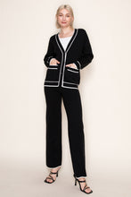 Load image into Gallery viewer, Woman wearing a black outfit with white trim on a plain background