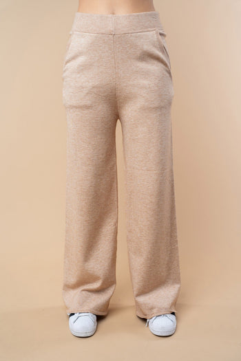 Beige wide-leg pants worn by a person on a beige background