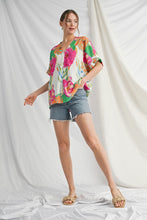 Load image into Gallery viewer, Woman wearing a colorful floral blouse and denim shorts on a white background
