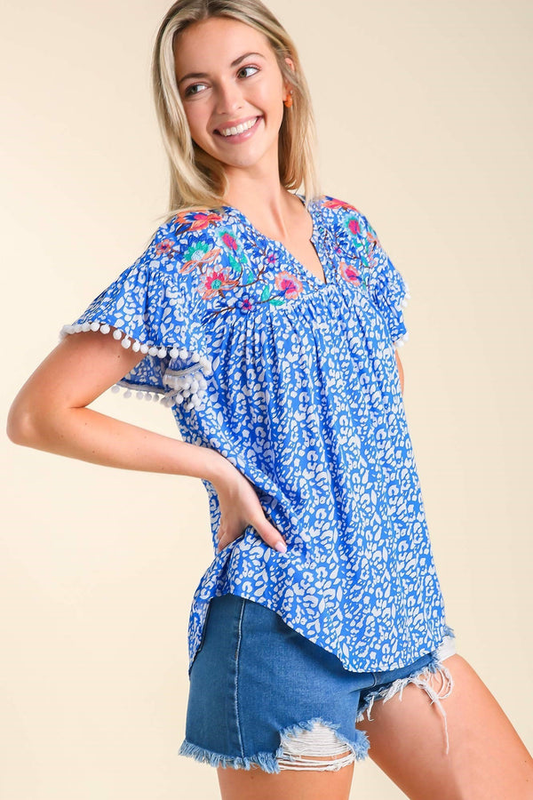 Umgee Animal Print Top with Flower Embroidery and Pom Pom Fringe Detail in Royal Top Umgee   