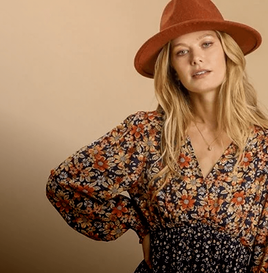 Woman wearing a floral dress and brown hat against a beige background