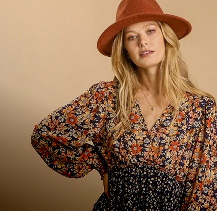 Woman wearing a floral dress and brown hat against a beige background
